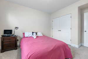 Carpeted bedroom featuring a closet