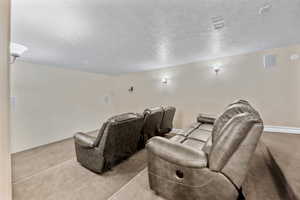 Carpeted home theater room with a textured ceiling