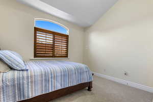 Bedroom with carpet and vaulted ceiling