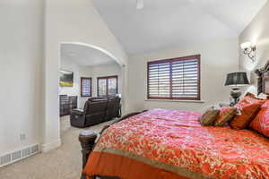 Bedroom featuring carpet flooring, ceiling fan, and vaulted ceiling