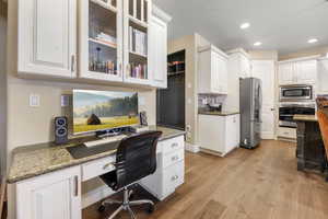 Office featuring built in desk and light hardwood / wood-style flooring