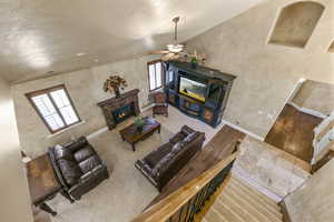 Living room with ceiling fan, a healthy amount of sunlight, vaulted ceiling, and wood-type flooring