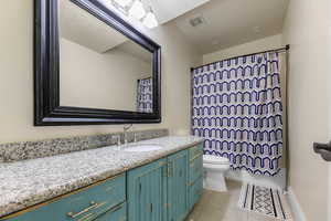 Bathroom featuring tile patterned flooring, vanity, and toilet