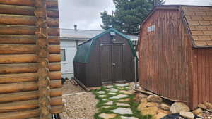 View of side of home with a shed