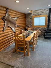 Dining room with rustic walls and a wood stove