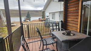 Wooden deck with an outdoor fire pit and a water view