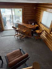 Dining area featuring carpet and log walls