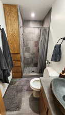 Bathroom featuring vanity, a shower with curtain, toilet, and tile patterned floors