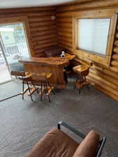 Bar featuring carpet and log walls