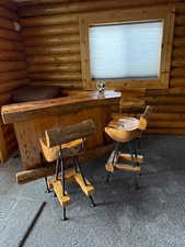 Sitting room with carpet floors, indoor bar, and log walls