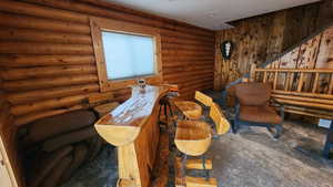 Sitting room featuring rustic walls and dark colored carpet