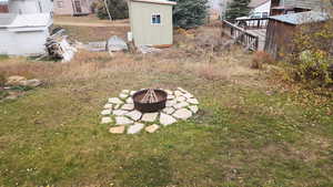 View of yard featuring a storage shed, a deck, and a fire pit