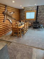 Dining space with rustic walls and a wood stove