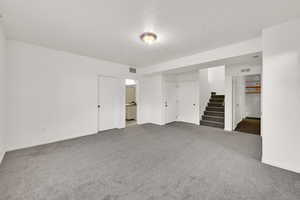 Carpeted spare room with a textured ceiling