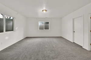 Empty room with carpet and a textured ceiling