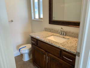 Bathroom with vanity, toilet, and tile patterned floors