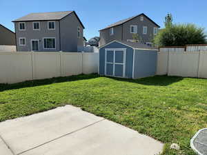 View of yard featuring a patio and a shed