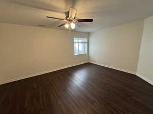 Spare room featuring ceiling fan, a textured ceiling, and dark hardwood / wood-style flooring