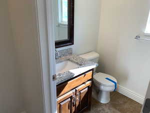 Bathroom featuring vanity, toilet, and tile patterned floors