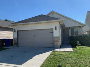 View of front of home with a garage and a front lawn