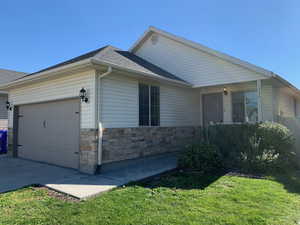 View of property exterior with a garage and a lawn