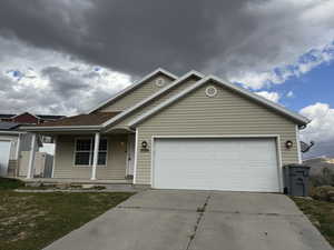 View of front of property with a front yard and a garage