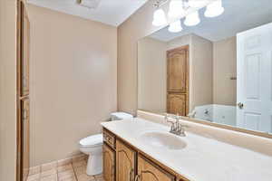 Bathroom with vanity, toilet, and tile patterned flooring