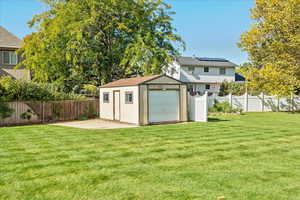 Rear view of house with a yard and an outbuilding