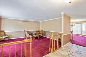 Interior space with crown molding, a notable chandelier, and a textured ceiling