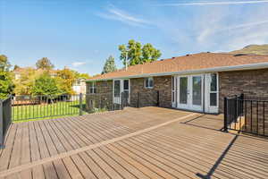 Wooden deck featuring a yard and french doors