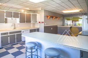 Kitchen featuring plenty of natural light, kitchen peninsula, white refrigerator, and electric stove