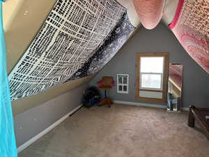 Additional living space with carpet and lofted ceiling