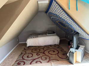 Bedroom with carpet flooring and vaulted ceiling