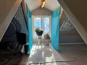 Interior space featuring carpet, lofted ceiling, and a textured ceiling