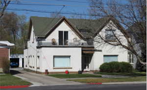 View of front facade with a front yard and a balcony