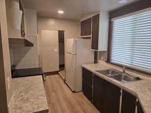 Kitchen with a healthy amount of sunlight, tasteful backsplash, sink, and light wood-type flooring