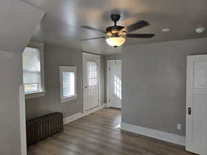 Entryway featuring ceiling fan, hardwood / wood-style flooring, and radiator