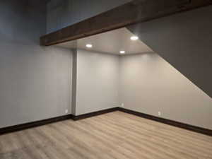 Basement with light hardwood / wood-style floors