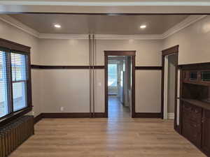 Interior space featuring light hardwood / wood-style floors, crown molding, and radiator heating unit