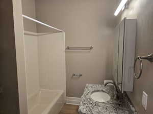 Bathroom featuring vanity, hardwood / wood-style flooring, and shower / tub combination