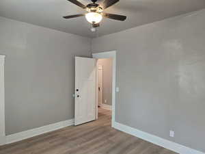 Unfurnished room with light wood-type flooring and ceiling fan