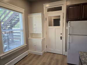 Interior space featuring baseboard heating and light hardwood / wood-style floors