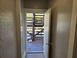 Doorway with brick wall and light wood-type flooring