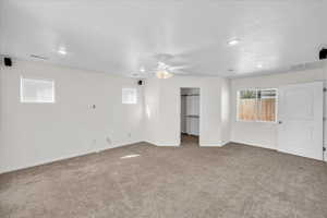 Unfurnished bedroom featuring ceiling fan, carpet, and a textured ceiling