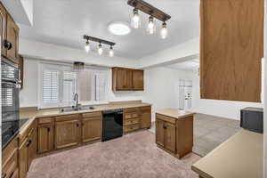 Kitchen with black appliances, sink, and a kitchen island