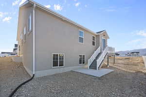 Rear view of property featuring a mountain view and a patio area