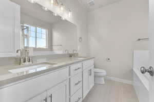 Bathroom featuring tile patterned floors, vanity, and toilet