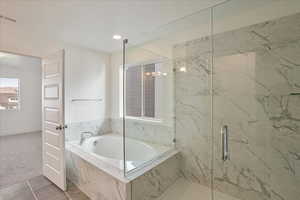 Bathroom featuring plus walk in shower and tile patterned flooring