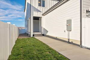 View of side of property with a patio and a lawn