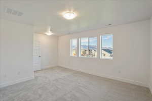 Carpeted empty room featuring a textured ceiling